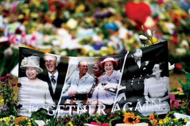 گزشتہ روز لندن میں بکنگھم پیلس کے باہر پھولوں کے گلدستے کے درمیان آنجہانی ملکہ کی تصاویر دیکھی جا سکتی ہیں (ای پی اے)