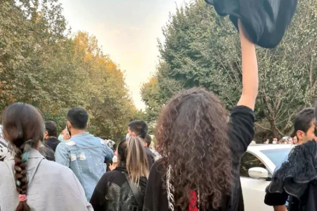 إيرانيات ينزعن الحجاب خلال احتجاجات بمحيط جامعة طهران أول من أمس (تويتر)