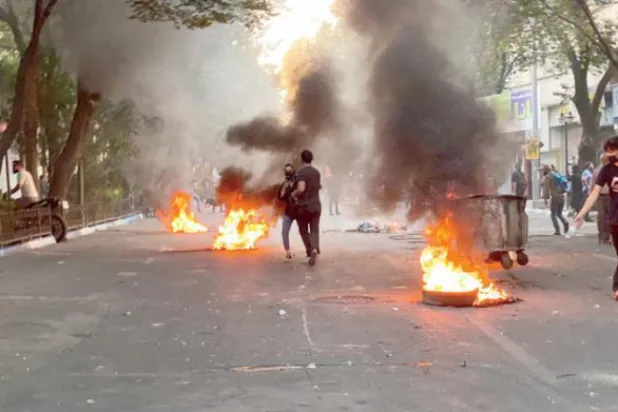 مظاہرین کو پرسو روز وسطی تہران میں ایک گلی میں آگ زنی کرتے ہوئے دیکھا جا سکتا ہے