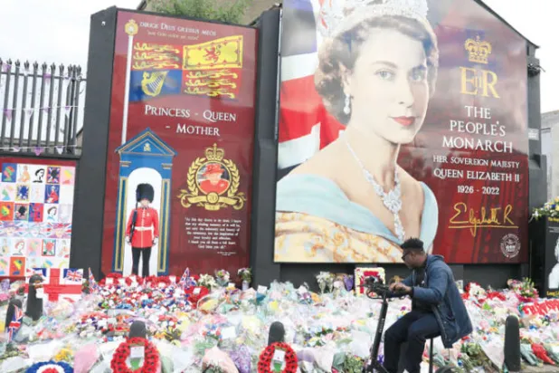 باقات زهور قرب صورة للملكة الراحلة إليزابيث الثانية في حي شانكيل بغرب بلفاست يوم 19 سبتمبر (أ.ب)