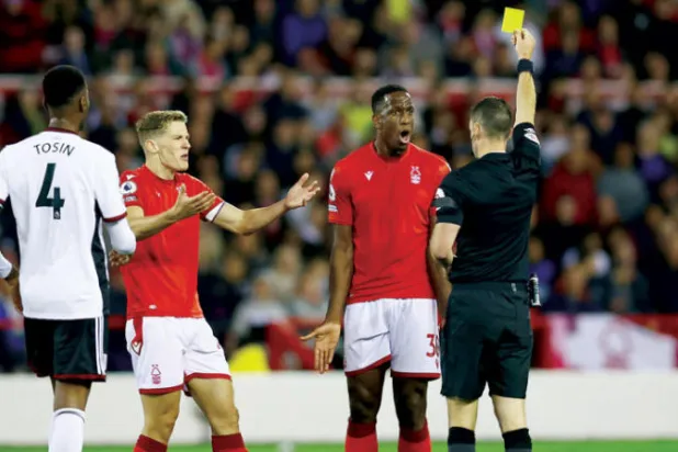 الحكم يشهر البطاقة الصفراء في  وجه ويلي بولي مدافع فورست خلال الهزيمة الأخيرة أمام فولهام  (رويترز)