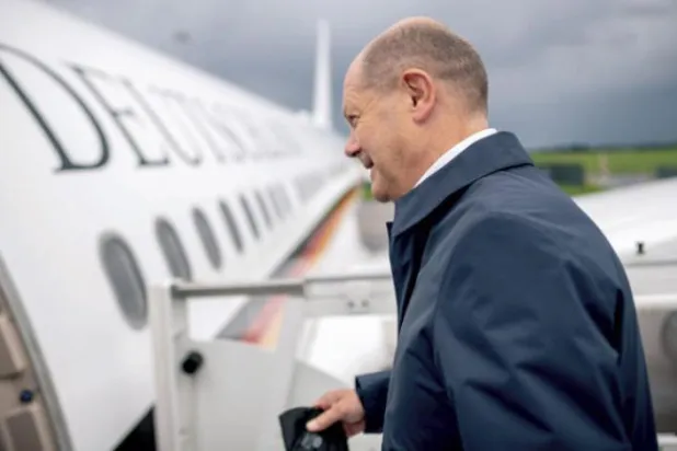 German Chancellor Olaf Scholz boarding a place (dpa)