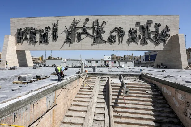Municipal workers perform works at the Freedom Monument in Tahrir Square in the center of Iraq's capital Baghdad on September 24, 2022. (AFP)