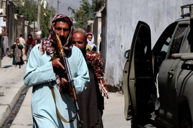 مقاتلو «طالبان» يقفون في حراسة خارج مركز تعليمي في غرب العاصمة الأفغانية بعد تعرضه لتفجير انتحاري أمس (أ.ف.ب)