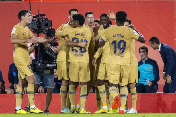 ليفاندوفسكي فرحاً مع زملائه بهدف الفوز (إ.ب.أ)