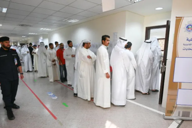 الكويتيون خلال إدلائهم بأصواتهم في انتخابات مجلس الأمة (إ.ب.أ)