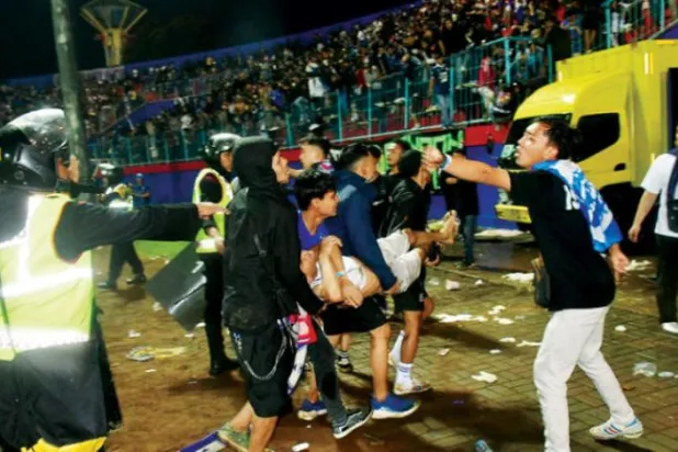 پیرامیڈیکس انڈونیشیا اسٹیڈیم کے حادثے میں زخمیوں میں سے ایک کو بچانے کی کوشش کر رہے ہیں (رائٹرز)