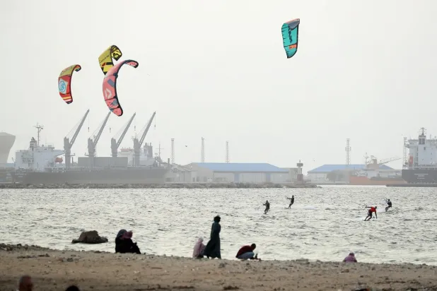 People watch kitesurfers practice on the Mediterranean shore of Libya's capital Tripoli, on October 1, 2022. (AFP)