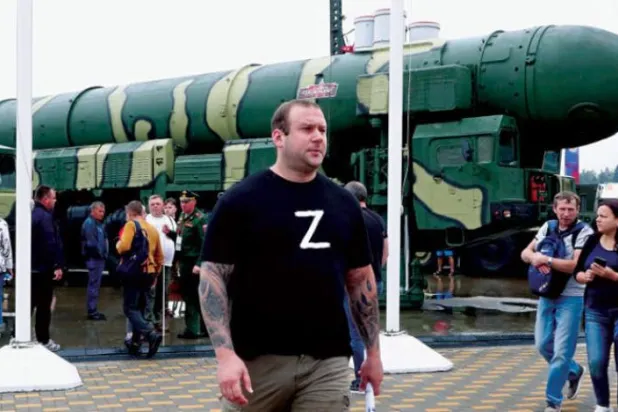 20 Ağustos 2022’de Moskova’daki bir askeri sergide balistik füzenin önünden geçen ziyaretçiler (EPA)