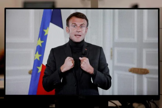 الرئيس الفرنسي إيمانويل ماكرون يرتدي ملابس شتوية دافئة (أ.ف.ب)