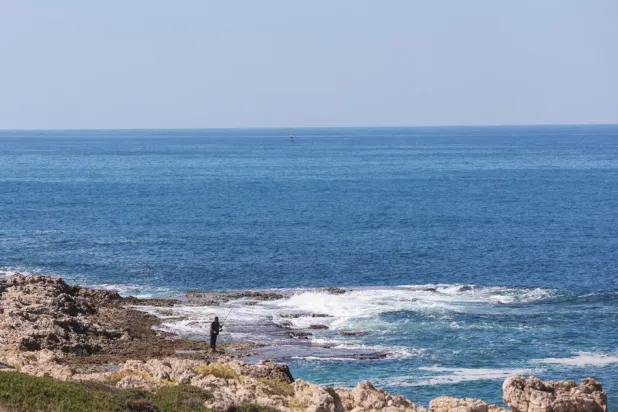 A fisherman dangles his line to catch fish, in Naqoura, near the Lebanese-Israeli border, southern Lebanon, October 6, 2022. REUTERS/Aziz Taher
