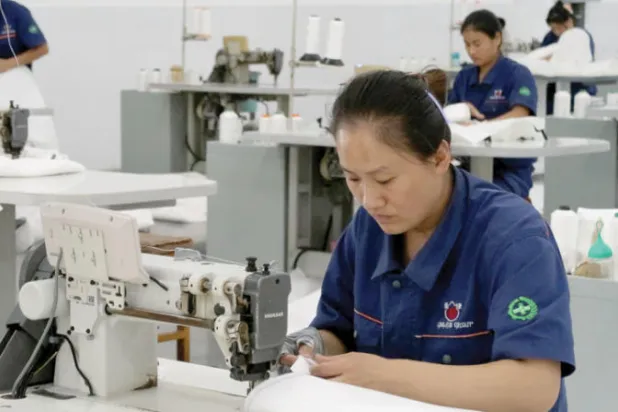 عاملات يعملن في مصنع للملابس في مقاطعة صينية (رويترز)