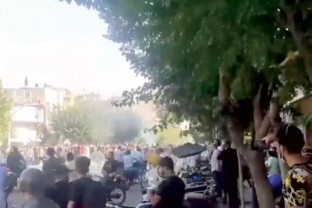 کل تہران بازار میں پولیس بوتھ میں آگ لگنے کے درمیان ایک احتجاجی مارچ کے منظر کو دیکھا جا سکتا ہے (ٹویٹر)