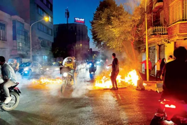گزشتہ روز مرکزی تہران میں سکیورٹی فورسز کی نقل و حرکت کو روکنے کے لیے مظاہرین نے ایک گلی میں آگ لگا دی  (اے ایف پی)