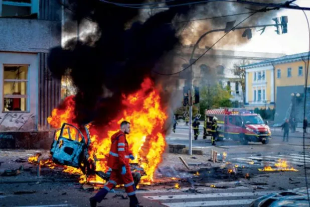 کل کیو میں روسی بمباری کے بعد ایک طبی کارکن کو جلتی ہوئی کار کے آگے چلتے ہوئے دیکھا جا سکتا ہے (اے بی)