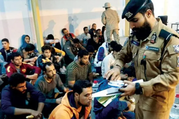 Libyan security guard gathering documents of migrants (IOM)
