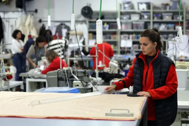موظفة تعمل في أحد مصانع الملابس بإسبانيا (أ.ف.ب)