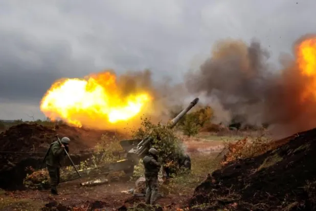 İki Rus askeri Donetsk’te Ukrayna mevzisine doğru atış yapıyor (AP)