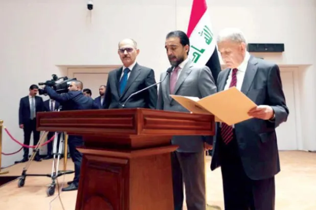 Rashid taking the oath after his election, alongside Parliament Speaker Muhammad al-Halbousi (INA)