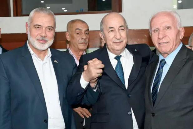 صورة وزعتها الرئاسة الجزائرية لزيارة تبون مقر المؤتمر الفلسطيني (أ.ف.ب)