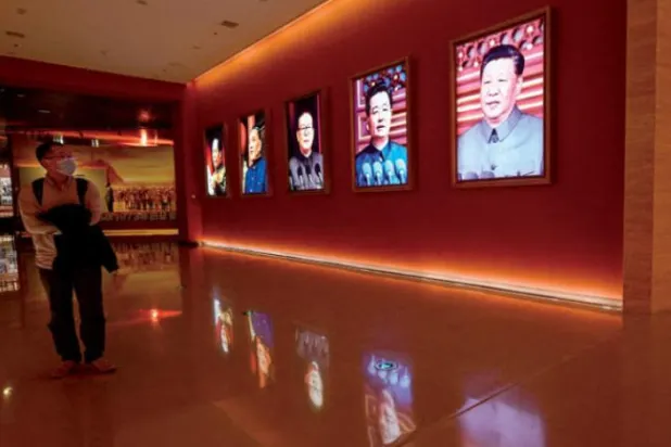 کل یانان میں ایک شخص کو چینی صدور کی تصویروں سے گزرتے ہوئے دیکھا جا سکتا ہے (اے ایف پی)