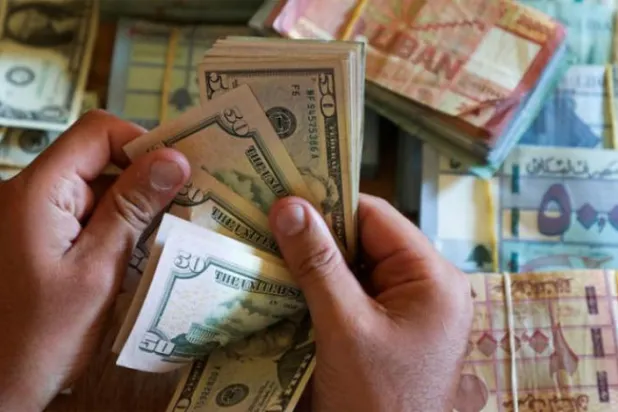 بیروت میں منی چینجر کے پاس لبنانی اور امریکی کرنسی (رائٹرز)