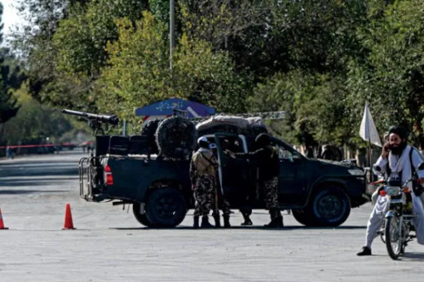 Terör saldırısının ardından Kabil Üniversitesi dışında Taliban tarafından güvenlik uyarısı yapılıyor (AFP)