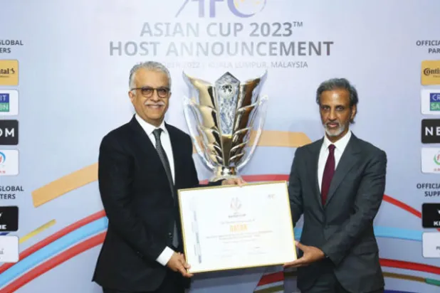 الشيخ سلمان آل خليفة وهو يسلم شهادة الاستضافة لرئيس الاتحاد القطري (إ.ب.أ)