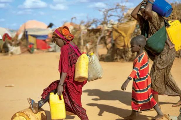 الجفاف أوصل الصومال إلى حافة المجاعة، هنا سيدة صومالية وأطفالها ينقلون الماء إلى مخيم لللاجئين (أ.ب)