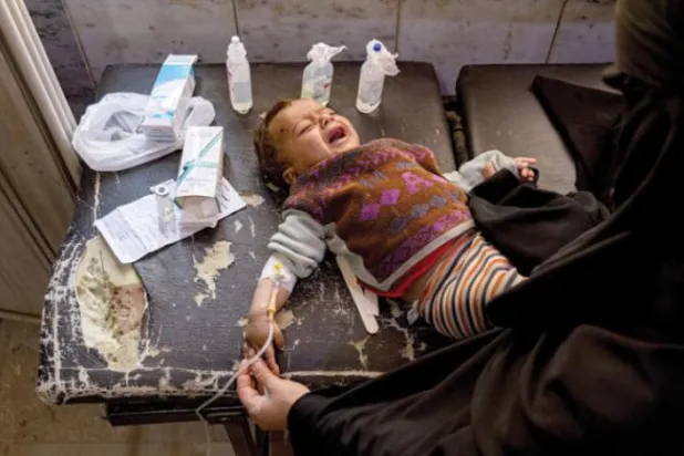 A Syrian woman with her cholera-infected child (AP)