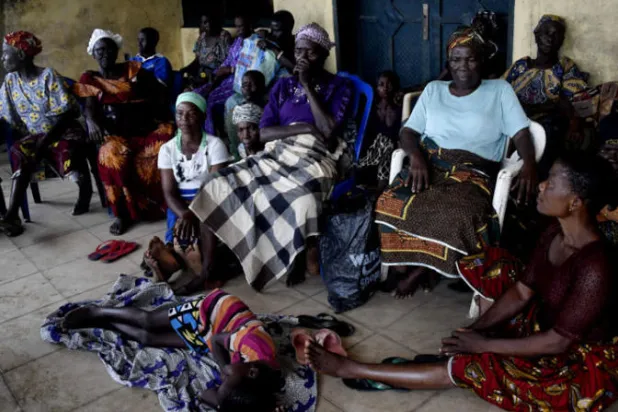 نساء يجلسن في مخيم للنازحين حيث يتم إيواءهن من الفيضانات في مدرسة المجتمع الابتدائية بمنطقة دلتا النيجر ولاية ريفرز (أ.ف.ب)