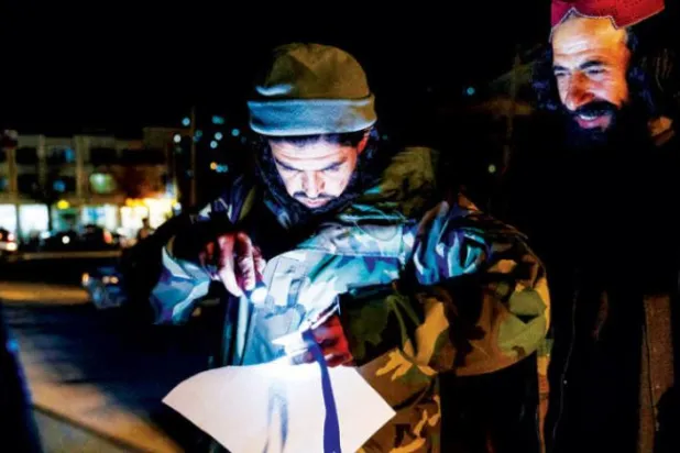 Kabil'deki bir kontrol noktasında kimlik kontrolü yapan Taliban üyesi (AFP)