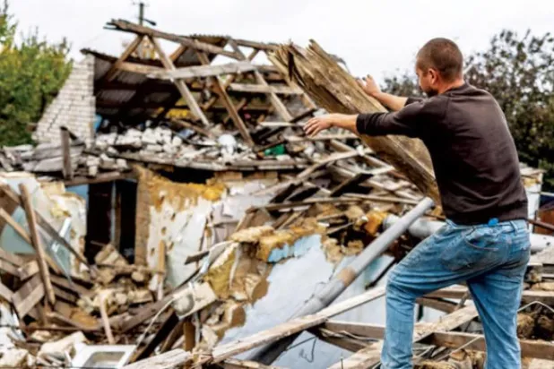 یوکرین کا ایک شہری کھیرسن کے قریب ایک گاؤں کو یوکرین کی افواج کے دوبارہ قبضے میں لینے کے بعد اپنے گھر کو مرمت کرنے کی کوشش کر رہا ہے (ای.پی.اے)