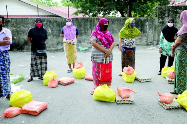 لاجئون من الروهينغا بانتظار تسلم مساعدات في كوالالمبور أبريل الماضي (رويترز)