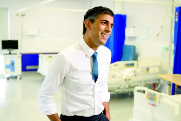 رئيس الوزراء البريطاني ريشي سوناك يتحدث مع ممثلي وسائل الإعلام أثناء زيارته مستشفى جامعة كرويدون في لندن أمس (رويترز)