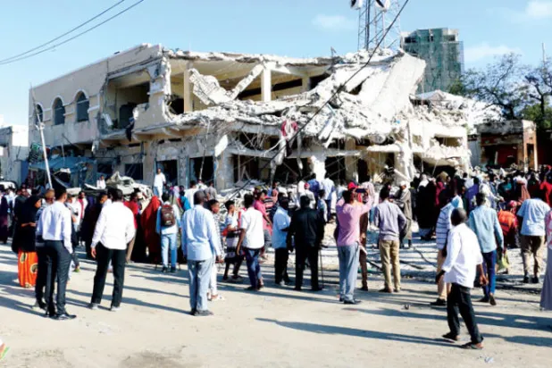 صوماليون أمام موقع التفجير الإرهابي أمس (إ.ب.أ)