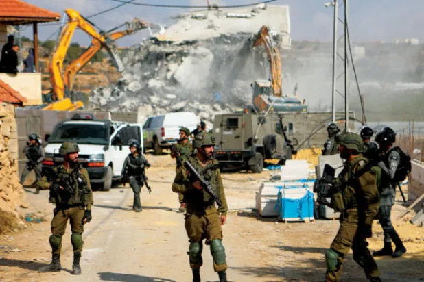 هدم الجرافات الإسرائيلية بناية تعود ملكيتها لفلسطيني في الخليل بالضفة الاثنين (د.ب.أ)