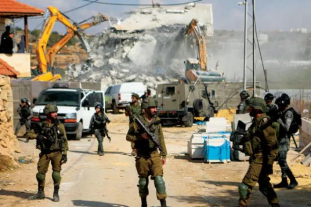 İsrail buldozerleri dün, Batı Şeria’nın el-Halil bölgesinde Filistinlilere ait bir binayı yıktı. (DPA)