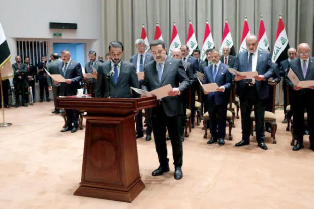السوداني وأعضاء حكومته خلال تأديتهم اليمين الدستورية في 27 أكتوبر (إ.ب.أ)