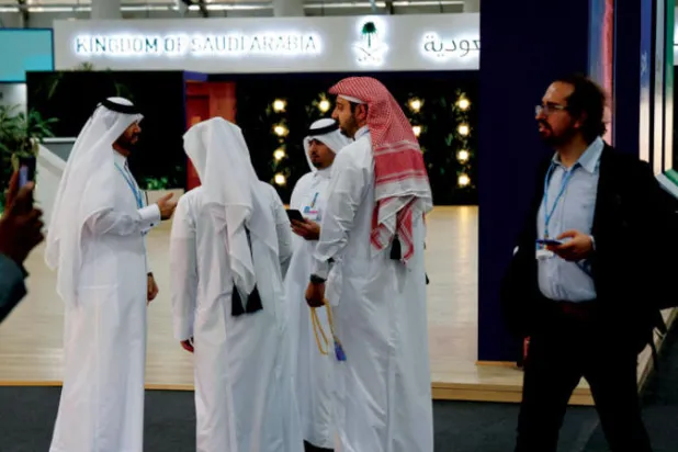 مشاركون في قمة «كوب 27» بمدينة شرم الشيخ أمام الجناح السعودي في قاعة المؤتمرات (أ.ف.ب)