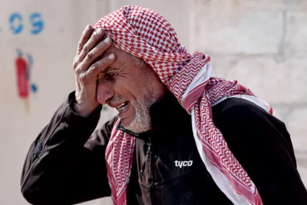 سوري يبكي وفاة طفله بهجوم صاروخي من قوات النظام على مخيم «مرام» للنازحين بإدلب (د.ب.أ)