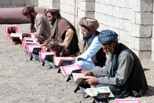 عناصر وقيادات طالبات يقرأون القرآن امام قبر المؤسس الملا محمد عمر ( (أ.ب.إ)