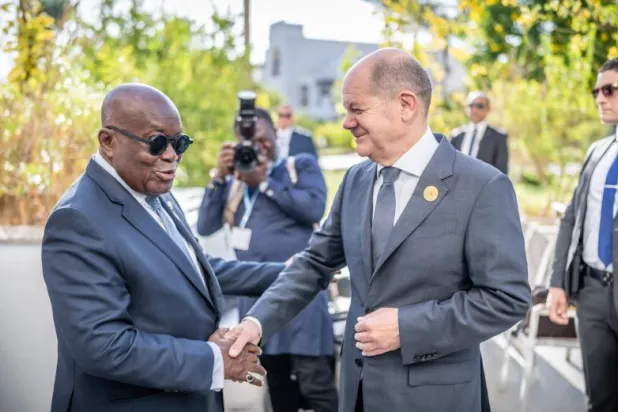 شولتس يصافح رئيس غانا على هامش مؤتمر المناخ في شرم الشيخ اليوم (د.ب.أ)