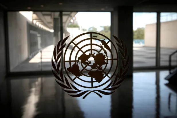 The United Nations logo is seen on a window in an empty hallway at United Nations headquarters during the 75th annual UN General Assembly high-level debate in New York, US, September 21, 2020. REUTERS/Mike Segar