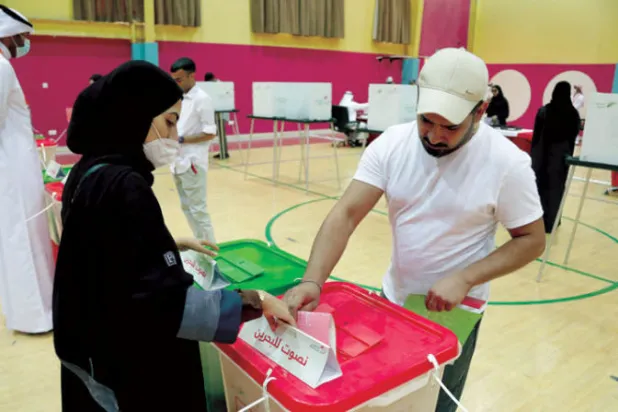 بحرينية تدلي بصوتها في أحد مراكز الاقتراع يوم السبت (أ.ف.ب)