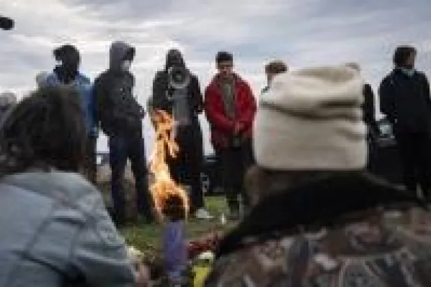 مهاجرون تجمعوا لوداع زميل لهم قضى بعدما دهسته سيارة في مدينة فينتيميليا الإيطالية قرب الحدود الفرنسية (أ.ب)