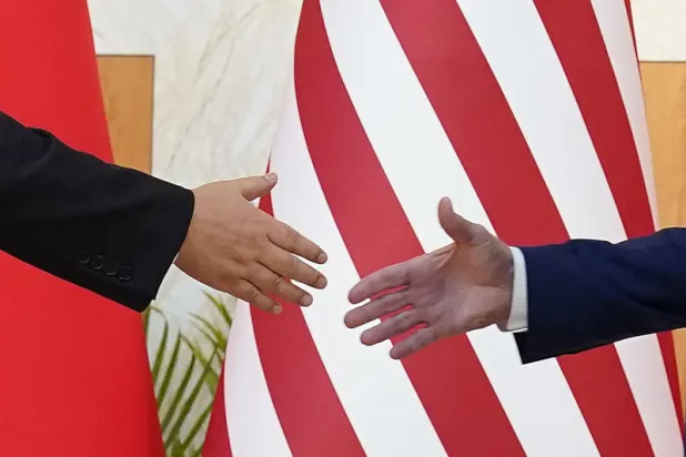 يدا الرئيس الأميركي جو بايدن - يمين - والصيني شي جينبينغ تلتقيان في مصافحة (أ.ب)