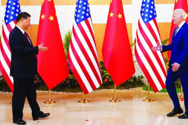 الرئيسان الأميركي جو بايدن والصيني شي جينبينغ يهمان بمصافحة أحدهما الآخر في مستهل لقائهما في بالي أمس (رويترز)