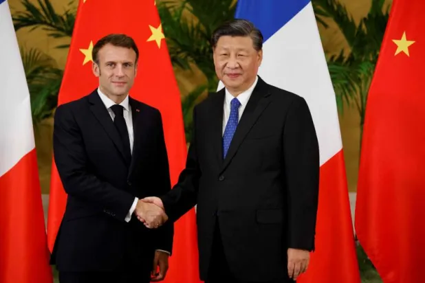 الرئيس الفرنسي إيمانويل ماكرون (يسار) ونظيره الصيني شي جينبينغ (أ.ف.ب)