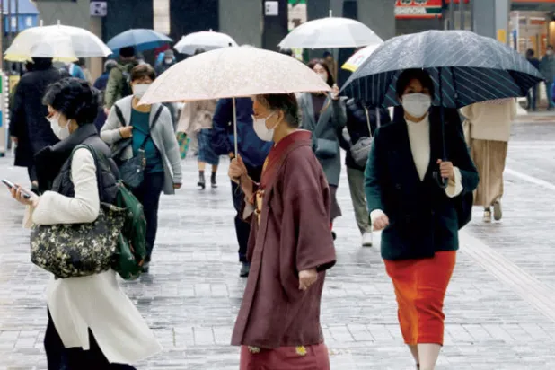 يابانيات بالزي التقليدي في منطقة تجارية بالعاصمة طوكيو (رويترز)